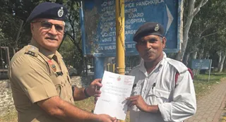 होमगार्ड जवान संजीव कुमार को प्रशंसा पत्र सौंपते पुलिस अधिकारी।