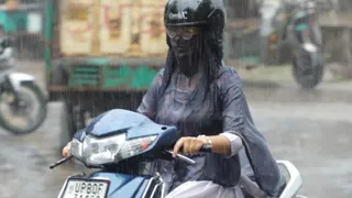 आगरा में शुक्रवार सुबह बारिश में भीगते हुए कॉलेज जाती छात्रा।