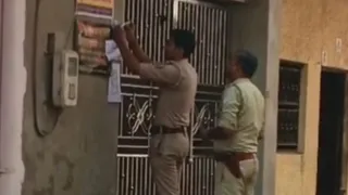 भाजपा पार्षद किशन नायक के घर पर कुर्की पूर्व कार्रवाई का नोटिस चिपकाते पुलिसकर्मी।