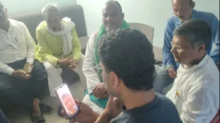 दिवंगत अधिकारी के बेटे से बात करते तेजस्वी यादव।