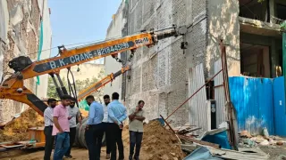 सुशांत लोक एक में निर्माणाधीन बिल्डिंग के झुकने के बाद मौके का निरीक्षण करते इंजीनियर और सपोर्ट के लिए लगाई गई क्रेन। फोटो: जागरण