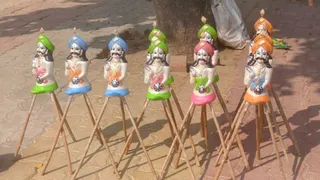 दुकान पर बिक्री के लिए टेसू सजाकर रखे कुम्हार