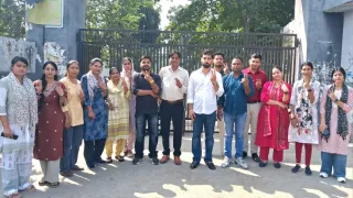 पोलिंग बूथ पर मतदान करने के बाद निशान दिखाते शिक्षक
