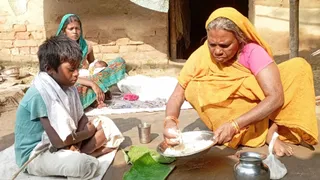 मृतक के अग्निकर्ता पुत्र को भोजन परोसती मृतक की मां। पीछे बैठी मृतक की पत्नी। जागरण