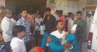 घायल को एंबुलेंस ले जाते स्वजन व जुटी भीड़।