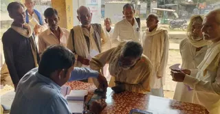 कुरारा में किसान का अंगूठा लगवाते खाद केंद्र प्रभारी। जागरण