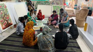 स्थानीय कलाकारों से आदिवासी बैगा आर्ट के बारे में चर्चा करतीं विदेशी चित्रकार।