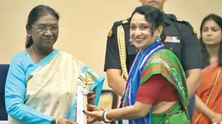 राजकीयकृत मध्य विद्यालय बरमसिया की प्रभारी प्रधानाध्यापिका मुनमुन भट्टाचार्य को शिक्षक दिवस के अवसर पर सम्मानित करतीं राष्ट्रपति द्रौपदी मुर्मु। (सौजन्यः स्वयं)