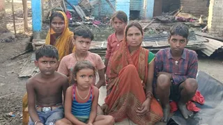 आगजनी के बाद खुले आसमान के नीचे बैठीं पीड़ित महिलाएं और उनके बेबस बच्चे।