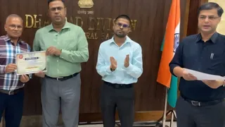 पदोन्नति प्रमाण पत्र साैंपते धनबाद के डीआरएम अखिलेश मिश्र। (फोटो साैजन्य)