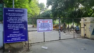 लोक कल्याण मार्ग स्थित रेस कोर्स के गेट पर लगा चेतावनी का बोर्ड और तैनात अर्ध सैनिक बल के जवान। चंद्र प्रकाश मिश्र