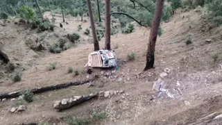 धनौड़ के लास्टगला में सड़क से नीचे खाई में गिरकर पेड़ों के बीच अटका टेंपो ट्रैवलर।