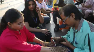 कनाॅट प्लेस स्थित हनुमान मंदिर परिसर में करवाचौथ के लिए मेंहदी लगवाती महिलाएं। चंद्र प्रकाश मिश्र