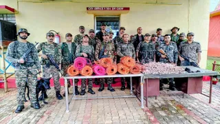 माओवादियों के ठिकाने से बरामद विस्फोटक और सामानों के साथ सुरक्षा बल के जवान। (फोटो साैजन्य)