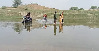 रिंद नदी में खूंटा गांव के घाट पर पानी कम होने के कारण पैदल नदी पार करते ग्रामीण। स्रोत आर्काइव