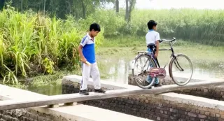 जान जोखिम में डाल नहर पार कर स्कूल जाते बच्चे। स्रोत: वीडियो ग्रैब