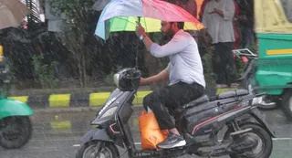 अर्नब साइक्लोन का असर गोरखपुर में भी,सुबह से हो रही वर्षा के कारण लोग परेशान रहे। बारिश से बचने के लिए छतरी के साथ जाता स्कूटर चालक। -अभिनव राजन चतुर्वेदी