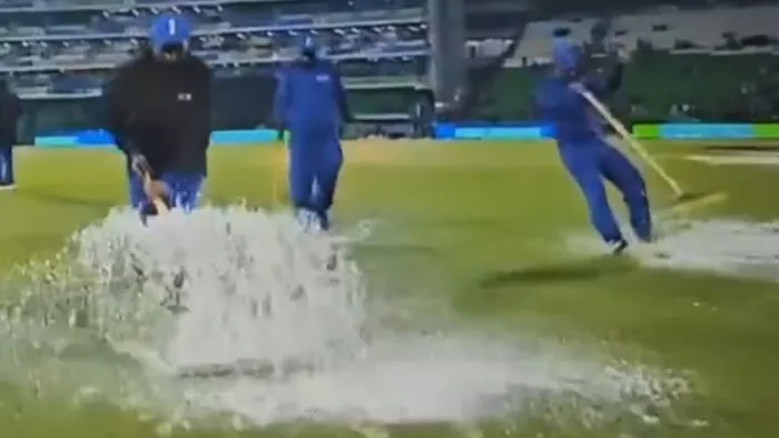 मैदान में पानी सूखाते हुए गिरा ग्राउंड स्टाफ का सदस्य