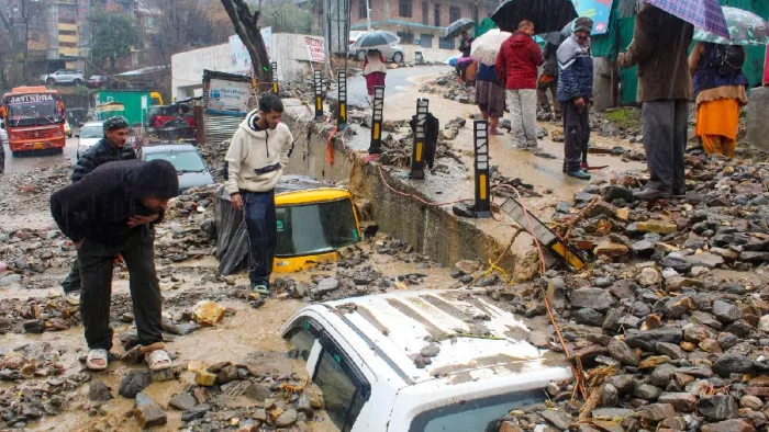 हिमाचल प्रदेश के कुल्लू में भारी वर्षा से भूस्खलन के बाद मलबे में दबे वाहन