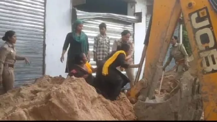 बुलडोजर के सामने खड़ी महिलाएं। वीडियो ग्रैब