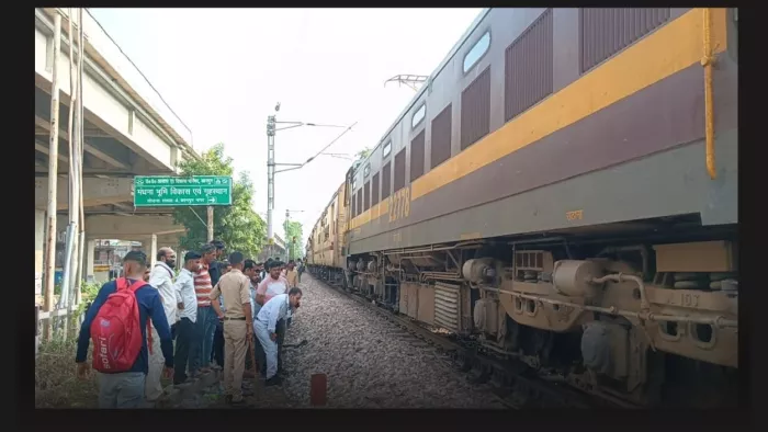 ट्रेन के इंजन के नीचे फंसे गोवंश को देखते रेलवे कर्मी। जागरण