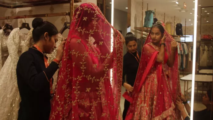 लगन लग गई: शो रूम में युवती को शादी वाले फैंसी लहंगा को पहनाती शोरूम की कर्मचारी। अभिनव राजन चतुर्वेदी