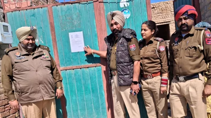 पुलिस ने नशा तस्कर के घर के बाहर चिपकाया पोस्टर। फोटो जागरण