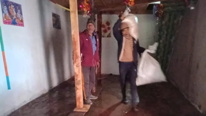 भूस्खलन के कारण अपने घर को छोड़कर जाते लोग