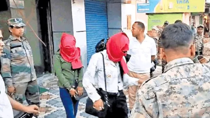 छापामारी के बाद पकड़ी गईं लड़कियों को ले जाती पुलिस।