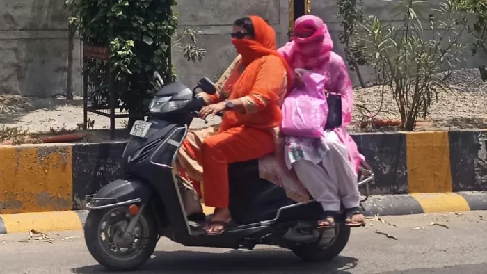 तेज धूप से बचने के लिए मुंह ढककर जाती महिलाएं। (फोटो- जागरण)