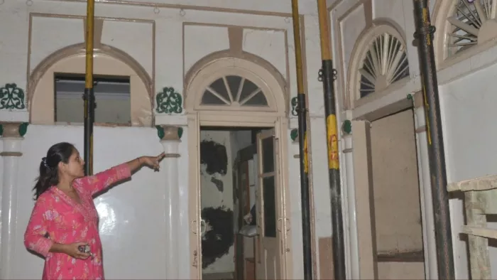 टनल खोदाई से चटकीं दीवारें और छत दिखातीं महिला।
