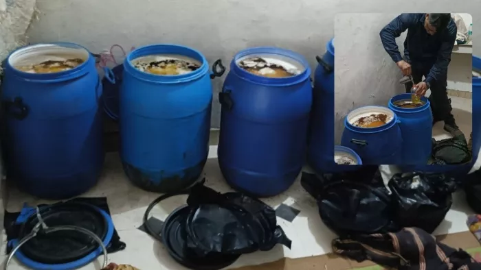 एत्मादपुर में पकड़ा गया नकली घी व जांच के लिए नमूने लेता कर्मचारी।