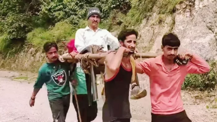 वर्षा के बाद सड़क क्षतिग्रस्त होने पर चारपाई पर मरीज को अस्पताल लाते मता गांववासी (फोटो: जागरण)