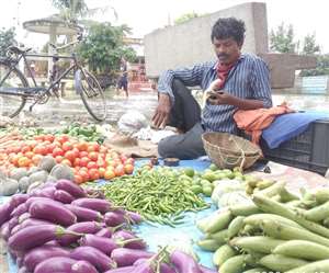 बाजार में हरी चमकीली सब्जियां बेचते दुकानदार