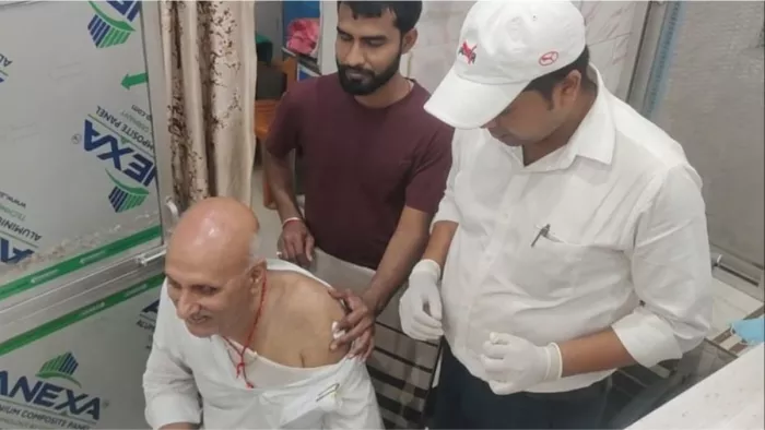विधायक प्रो. चंद्रशेखर का उपचार करते स्वास्थ्य कर्मी।