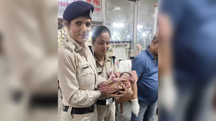 महिला सुरक्षा कर्मी बच्चे को गोद में लिए हुए।