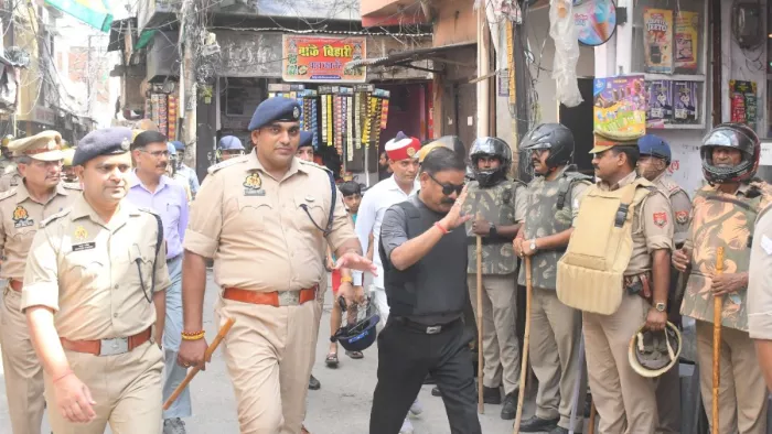 बिहारीपुर बजरिया में पैदल मार्च करते जिलाधिकारी अविनाश सिंह, एसएसपी अनुराग आर्य व अन्य अधिकारी।- जागरण