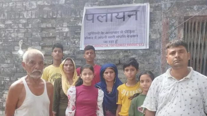 बांसगांव खास गांव स्थित अपने मकान पर पलायन का पोस्टर चस्पाकर स्वजन संग खड़े सच्चिदानंद पांडेय बाएं पहले। जागरण