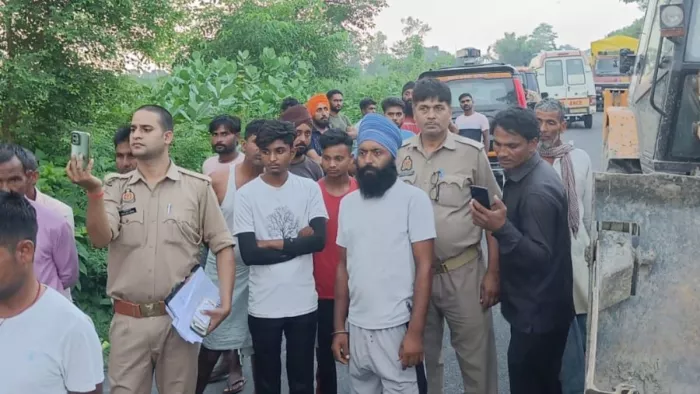 दुर्घटनाग्रस्त ट्रक से घायल को निकालती पुलिस व अन्य, वाहनों को हटाने के लिए आई जीसीबी ●जागरण।