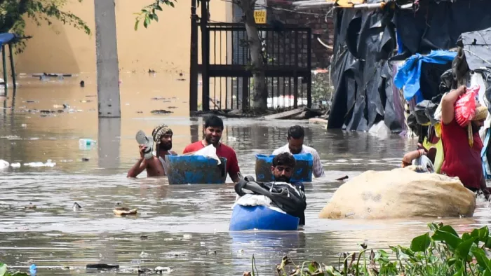 यमुना के बढ़े जलस्तर से उस्मानपुर गांव में पानी भरने पर सामान लेकर बाहर निकलते लोग। पारस कुमार