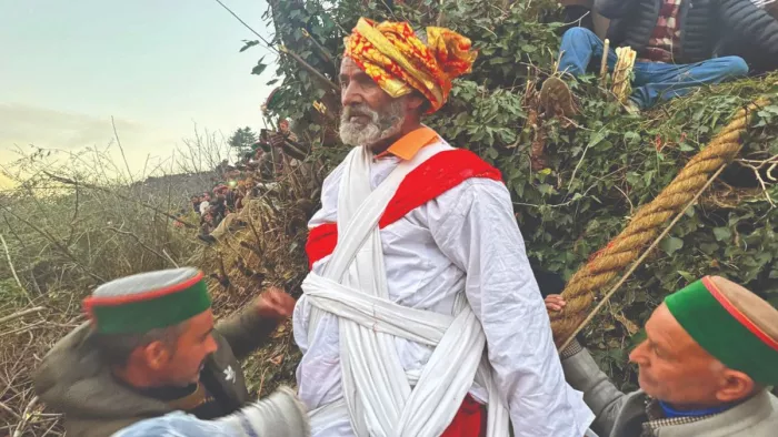 भूंडा महायज्ञ के दौरान रस्सी पर बैठ कर बेड़ा पार करते सूरत राम। (जागरण फोटो)