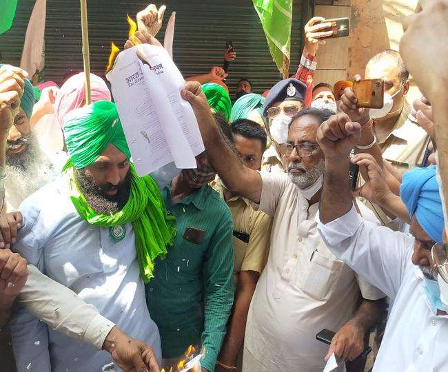 भाजपा नेता हनी गोयल और जिला प्रधान गौरव खुल्लर के घर के सामने कृषि कानून की प्रतियां जलाते किसान ।