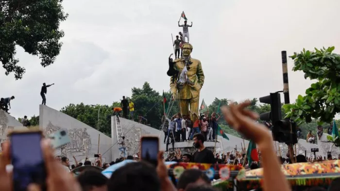 Bangladesh Violence: शेख मुजीबुर्रहमान की मूर्ति को क्षतिग्रस्त करते प्रदर्शनकारी। (फोटो- रॉयटर्स)