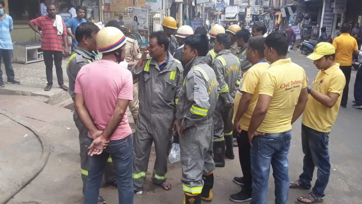 Agra News: आगरा के धूलियागंज मार्केट के बेसमेंट में धुआं भर जाने के चलते बाहर खड़े दमकलकर्मी।