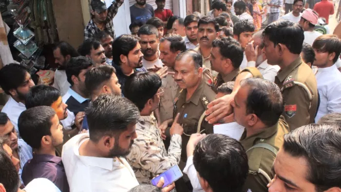 बांकेबिहारी क्षेत्र से अतिक्रमण हटाने पहुंचे पुलिस व नगर निगम कर्मचारियों से बहस करते व्यापारी।