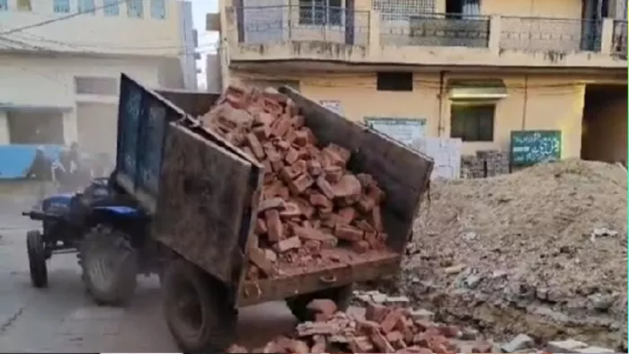 दीपा सराय चौक में बन रही पुलिस चौकी में लगाने के लिए ट्रॉली से उतरतीं ईंटें।- जागरण