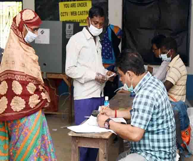 पश्चिम बंगाल के एक मतदान केंद्र पर अपना वोट डालते लोग