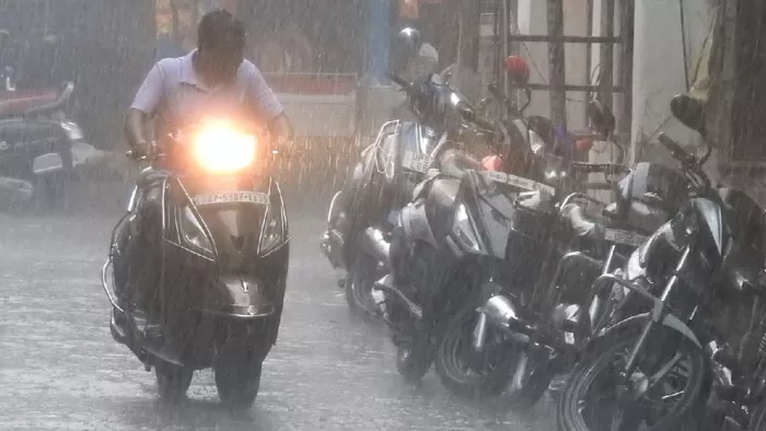 दिनभर लगातार हो रही वर्षा में आते जाते लोग। जागरण