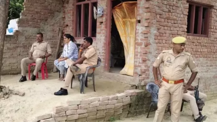 पीड़ित के घर जाने वाले मार्ग पर महिला पुलिस और वर्दी में निगरानी करते पुलिस टीम के जवान।- जागरण
