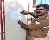 पीएम के दौरे में गडबडी फैलाने की आशंका में चिह्नित व्यक्ति के घर नोटिस चस्पा करता पुलिसकर्मी। जागरण